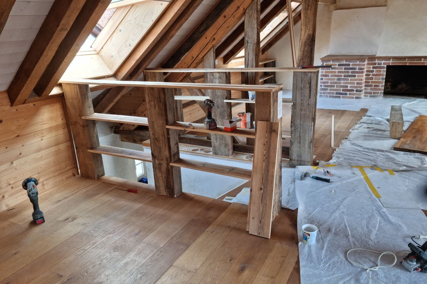 Combles avec charpente apparente et garde-corps en vieux bois monté entre les fermes