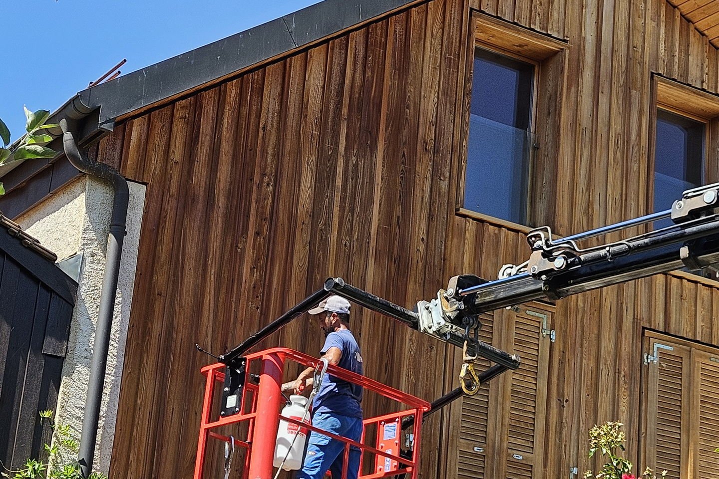 Ouvrier en nacelle appliquant le traitement sur les lames hautes du pignon