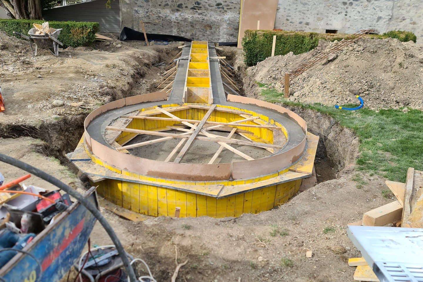 Coffrage circulaire en panneaux jaunes cintrés, posé dans une fouille avant coulage