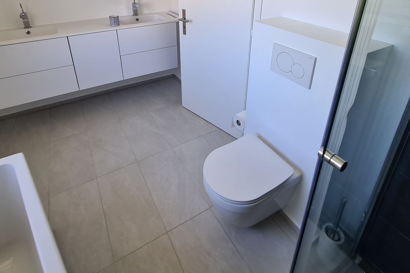 Salle de bains rénovée : meuble double vasque suspendu, WC suspendu, douche vitrée, carrelage grand format