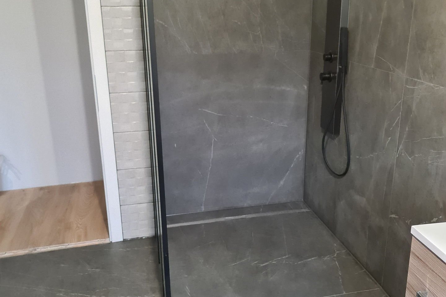 Douche de plain-pied avec paroi vitrée et carrelage grand format gris veiné
