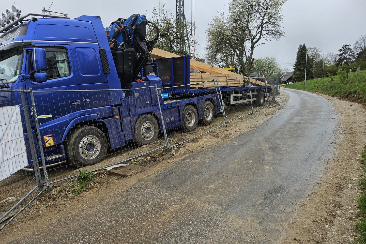 Le même camion vu de l’arrière, la charpente sanglée sur toute la longueur du plateau